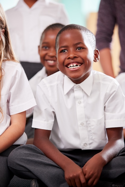 children in white shirts sitting on floor